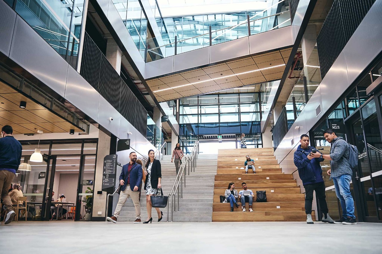 Modern glass building foyer with students about